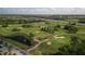 A picturesque golf course is showcased with lush greens, water features, and winding paths under a partly cloudy sky at 29408 Princeville Dr, San Antonio, FL 33576