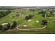 Aerial view of a lush green golf course with mature trees, ponds and sand traps at 29408 Princeville Dr, San Antonio, FL 33576