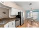 Bright kitchen with stainless steel appliances, granite countertops, and adjacent dining area with ample sunlight at 29408 Princeville Dr, San Antonio, FL 33576