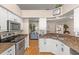 Open-concept kitchen with granite countertops, stainless appliances, and convenient access to other living spaces at 29408 Princeville Dr, San Antonio, FL 33576