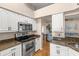Modern kitchen with stainless steel appliances, granite countertops, and convenient layout open to the living area at 29408 Princeville Dr, San Antonio, FL 33576