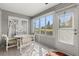 Sunroom with white tile floors and white walls, table, chairs, and views to the outside at 29408 Princeville Dr, San Antonio, FL 33576