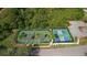 Aerial view of well-maintained tennis and pickleball courts, surrounded by lush greenery at 29408 Princeville Dr, San Antonio, FL 33576