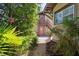 Exterior view of a two-story home with lush landscaping, a gravel path, and a private entrance at 307 Bay St, Tarpon Springs, FL 34689