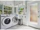 Bright laundry area featuring modern appliances, storage, and black and white tile at 307 Bay St, Tarpon Springs, FL 34689
