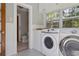 Well-lit laundry room with modern appliances and black and white tile flooring at 307 Bay St, Tarpon Springs, FL 34689