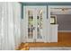 Bright living room features beautiful French doors with transom windows and gleaming hardwood floors at 307 Bay St, Tarpon Springs, FL 34689