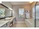 Bathroom featuring double vanity, soaking tub, and natural light at 308 Manns Harbor Dr, Apollo Beach, FL 33572