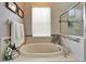 An inviting soaking tub with stone accents provides a luxurious retreat, complemented by natural light at 308 Manns Harbor Dr, Apollo Beach, FL 33572