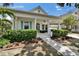 Inviting home featuring a covered front porch, mature landscaping, and an attached garage at 308 Manns Harbor Dr, Apollo Beach, FL 33572