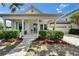 Charming home with a welcoming front porch, lush landscaping, and a convenient two-car garage at 308 Manns Harbor Dr, Apollo Beach, FL 33572