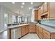 Well-lit kitchen offering stainless steel appliances, light wood cabinets, and a view towards the outdoor living space at 308 Manns Harbor Dr, Apollo Beach, FL 33572