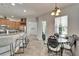 Bright kitchen with breakfast bar, wood cabinets, stainless steel appliances, and an adjacent dining area with decorative furniture at 308 Manns Harbor Dr, Apollo Beach, FL 33572