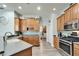 Bright kitchen with light wood cabinetry, stainless steel appliances, and an open view towards the laundry room at 308 Manns Harbor Dr, Apollo Beach, FL 33572