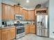 Modern kitchen featuring stainless steel appliances, gas range, light wood cabinetry, and ample countertop space at 308 Manns Harbor Dr, Apollo Beach, FL 33572