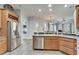 Spacious kitchen showcasing stainless steel appliances, wooden cabinets, and an open layout connecting to the living area at 308 Manns Harbor Dr, Apollo Beach, FL 33572