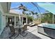 Covered patio with a fireplace, hot tub, lounge chairs, and dining table, perfect for outdoor living and entertaining at 308 Manns Harbor Dr, Apollo Beach, FL 33572