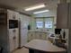 Functional kitchen features white cabinetry, a window above the sink, and essential appliances at 3114 Briar St. St, Wesley Chapel, FL 33543