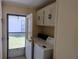 Practical laundry area features a washer, dryer, and overhead cabinets, optimizing functionality at 3114 Briar St. St, Wesley Chapel, FL 33543
