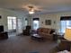 Comfortable living room with a ceiling fan, plush seating, and sliding door that leads to outside at 3114 Briar St. St, Wesley Chapel, FL 33543