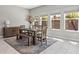 Bright dining room with large windows and wood table and bench at 32203 Wenlock Loop, Wesley Chapel, FL 33543