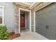 Inviting front entrance with a red door, stone accents, and an attached garage at 32203 Wenlock Loop, Wesley Chapel, FL 33543
