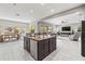 Open kitchen features a central island with barstool seating, stainless steel appliances, and white cabinetry at 32203 Wenlock Loop, Wesley Chapel, FL 33543