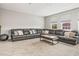 Spacious living room with a large sectional sofa, neutral carpet, and natural light at 32203 Wenlock Loop, Wesley Chapel, FL 33543
