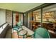An outdoor balcony with seating overlooks the greenspace and an indoor living space can be seen through the sliding glass doors at 36750 Us 19 N Hwy # 18-210, Palm Harbor, FL 34684