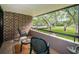 Relaxing balcony features green chairs, table, and expansive views of landscaped grounds at 36750 Us 19 N Hwy # 18-210, Palm Harbor, FL 34684