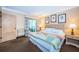 Bright bedroom featuring a queen bed, balcony access, and decorative floral drapes at 36750 Us 19 N Hwy # 18-210, Palm Harbor, FL 34684