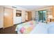 Well-lit bedroom with queen bed, closet with TV, and sliding glass doors to patio at 36750 Us 19 N Hwy # 18-210, Palm Harbor, FL 34684
