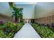 Inviting building entrance with a walkway lined with colorful landscaping and a modern facade at 36750 Us 19 N Hwy # 18-210, Palm Harbor, FL 34684
