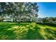 Building exterior with lush green lawn and shady trees at 36750 Us 19 N Hwy # 18-210, Palm Harbor, FL 34684