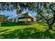 Building exterior with a lush lawn, mature tree and tidy shrubs at 36750 Us 19 N Hwy # 18-210, Palm Harbor, FL 34684