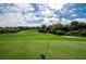 Beautiful golf course landscape with manicured greens and distant views of a blue house under a cloudy sky at 36750 Us 19 N Hwy # 18-210, Palm Harbor, FL 34684