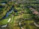 Aerial view of a lush golf course winding through the community, with mature trees and water features at 36750 Us 19 N Hwy # 18-210, Palm Harbor, FL 34684