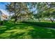 Mature trees provide shade to the wide green lawn at 36750 Us 19 N Hwy # 18-210, Palm Harbor, FL 34684