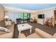 Inviting living room with sliding glass doors to balcony, comfortable seating, and neutral decor at 36750 Us 19 N Hwy # 18-210, Palm Harbor, FL 34684