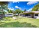 Lush backyard showcases green grass, a wooden deck with flowers, and a view of the screened-in lanai, creating an inviting retreat at 4110 Summerdale Dr, Tampa, FL 33624