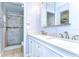 This bathroom features a double vanity and a marble shower with glass doors for a clean and modern look at 4110 Summerdale Dr, Tampa, FL 33624