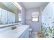 Well-lit bathroom features a classic vanity, framed mirror, and a shower with a floral curtain at 4110 Summerdale Dr, Tampa, FL 33624
