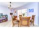 Dining area with round table, four upholstered chairs, and a view of the window with blinds at 4110 Summerdale Dr, Tampa, FL 33624
