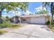 Well-kept single-story home with stone facade, green lawn, and driveway leading to a two-car garage at 4110 Summerdale Dr, Tampa, FL 33624