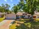Charming single-story home featuring a lush green lawn and mature trees providing shade and curb appeal at 6470 28Th N Ter, St Petersburg, FL 33710