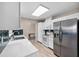 Bright, white kitchen with stainless steel refrigerator and view of dining area at 6470 28Th N Ter, St Petersburg, FL 33710