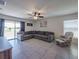 Comfortable living room with tile flooring, a large sectional sofa, and natural light from sliding glass doors at 659 Sunlit Coral St, Ruskin, FL 33570