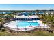 Community pool with inviting lounge areas, swaying palm trees, and a beautiful lake view at 659 Sunlit Coral St, Ruskin, FL 33570
