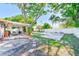 Expansive backyard with covered patio and mature trees, offering a serene outdoor space for relaxation at 700 16Th Nw St, Largo, FL 33770