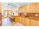 Bright kitchen with wood cabinets, tiled countertops, breakfast bar, and outdoor access at 700 16Th Nw St, Largo, FL 33770